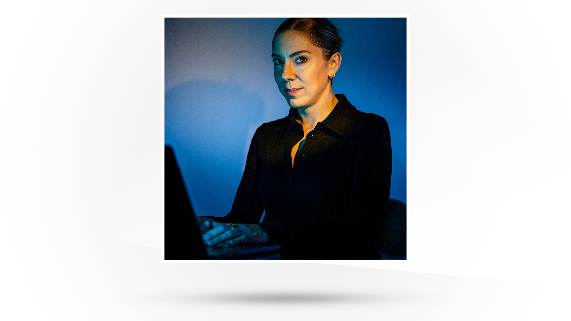 Photograph of a young woman seated at a laptop computer.