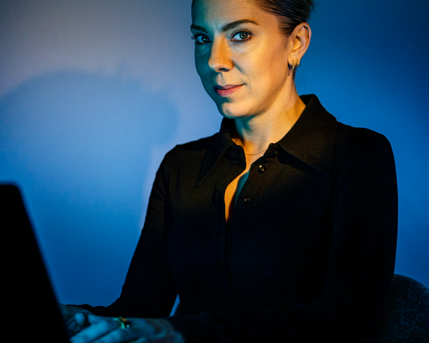 Photograph of a young woman seated at a laptop computer.